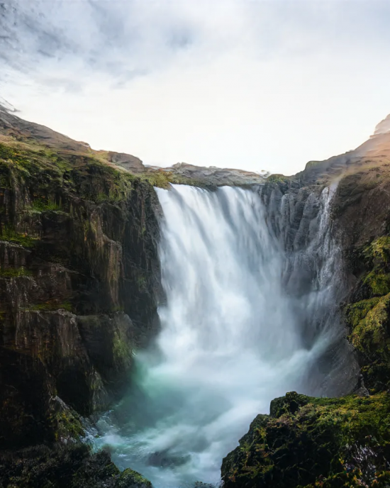 Under the setting sun, the waterfall falls